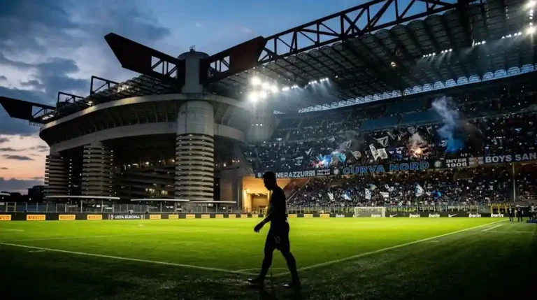 Vue panoramique du stade San Siro sous les projecteurs à la tombée de la nuit, illustrant le classement Inter Milan en Serie A.